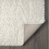 Cream shaggy runner rug with thick polyester fibers and a flexible backing, shown on dark hardwood floor.