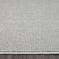 Grey flatweave rug with subtle geometric texture and clean stitched edges.