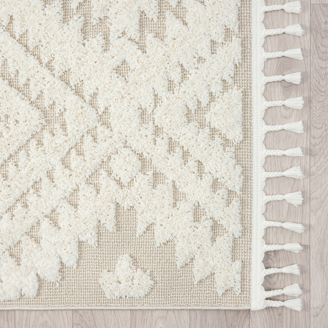Beige runner rug with raised white geometric pattern and white fringed edges.