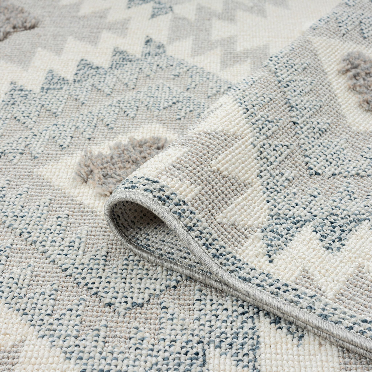 Grey and cream runner rug with textured geometric diamond pattern and fringed edges.