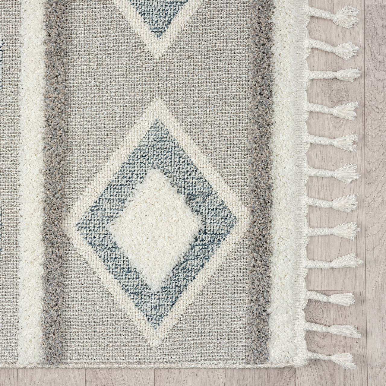 Grey and beige runner rug with modern geometric diamond pattern and fringe edges.