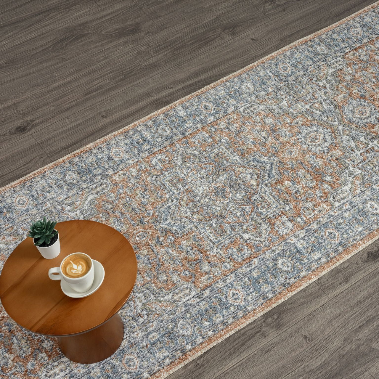 Indigo runner rug with intricate multi-color geometric and floral patterns on a muted background.