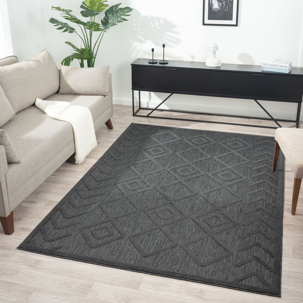 Charcoal grey rug with subtle geometric diamond pattern, textured polypropylene pile, modern style.