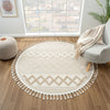 Beige and cream round rug with geometric diamond patterns and fringe edge on wood floor.