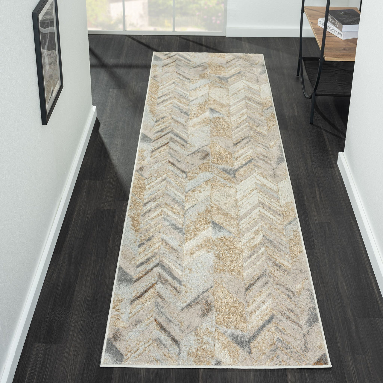 Multi-colored geometric patterned runner rug in beige, gray, and cream tones on dark wood floor.