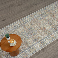 Long coral runner rug with intricate floral and geometric patterns in muted tones on wood floor.