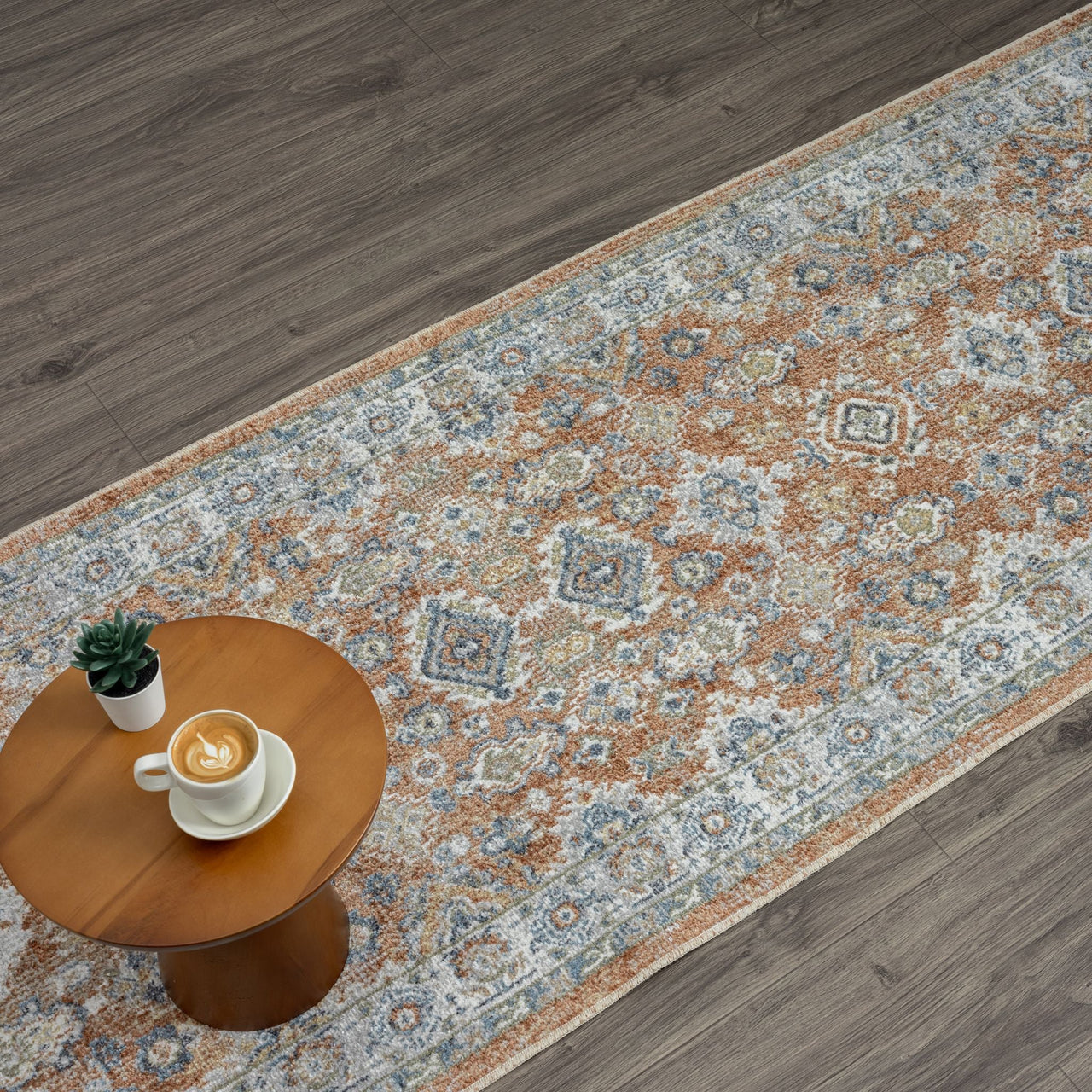 Multi-colored Easy 367 Terra Runner with intricate transitional pattern in beige, blue, and rust tones on wood floor.