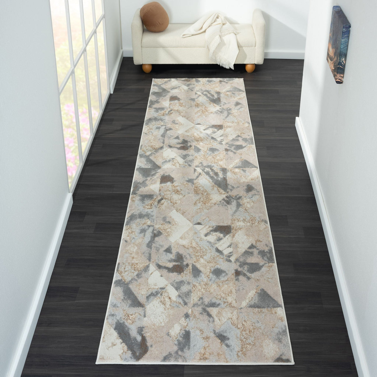 Modern runner rug with beige, gray, and soft brown geometric abstract pattern on light background.