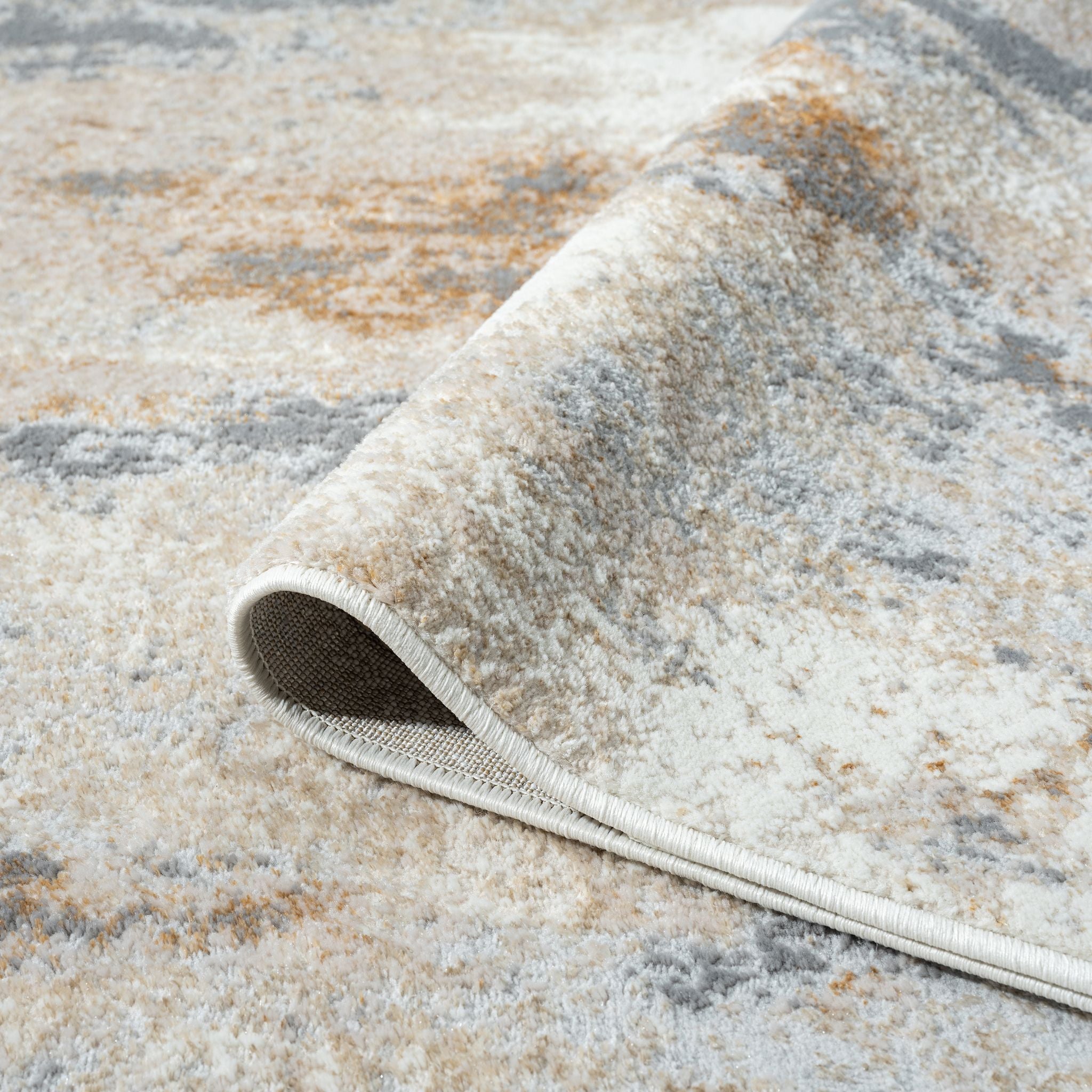 Textured area rug with a pattern of beige, brown, and gray colors.