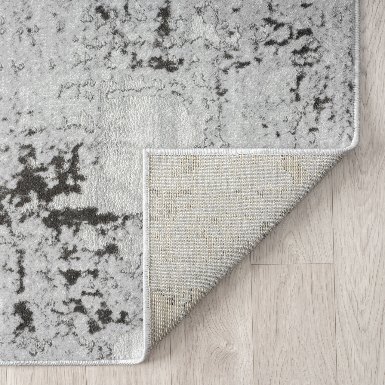 Gray and black patterned rug on a wooden floor