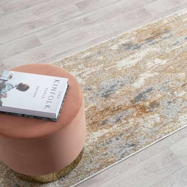 Pink stool with a book on a patterned rug