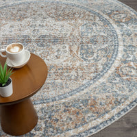 Round coral and blue patterned rug with distressed vintage design on hardwood floor.