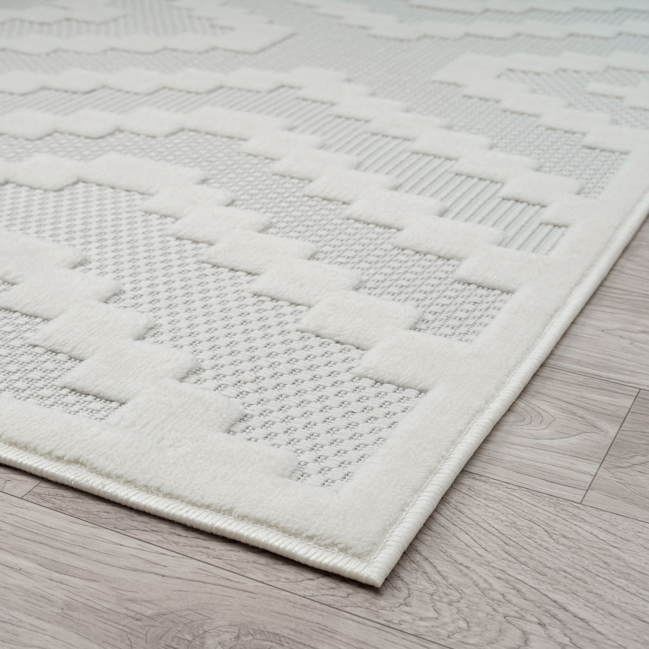 Cream runner rug with textured geometric patterns and a soft pile on light wood floor.