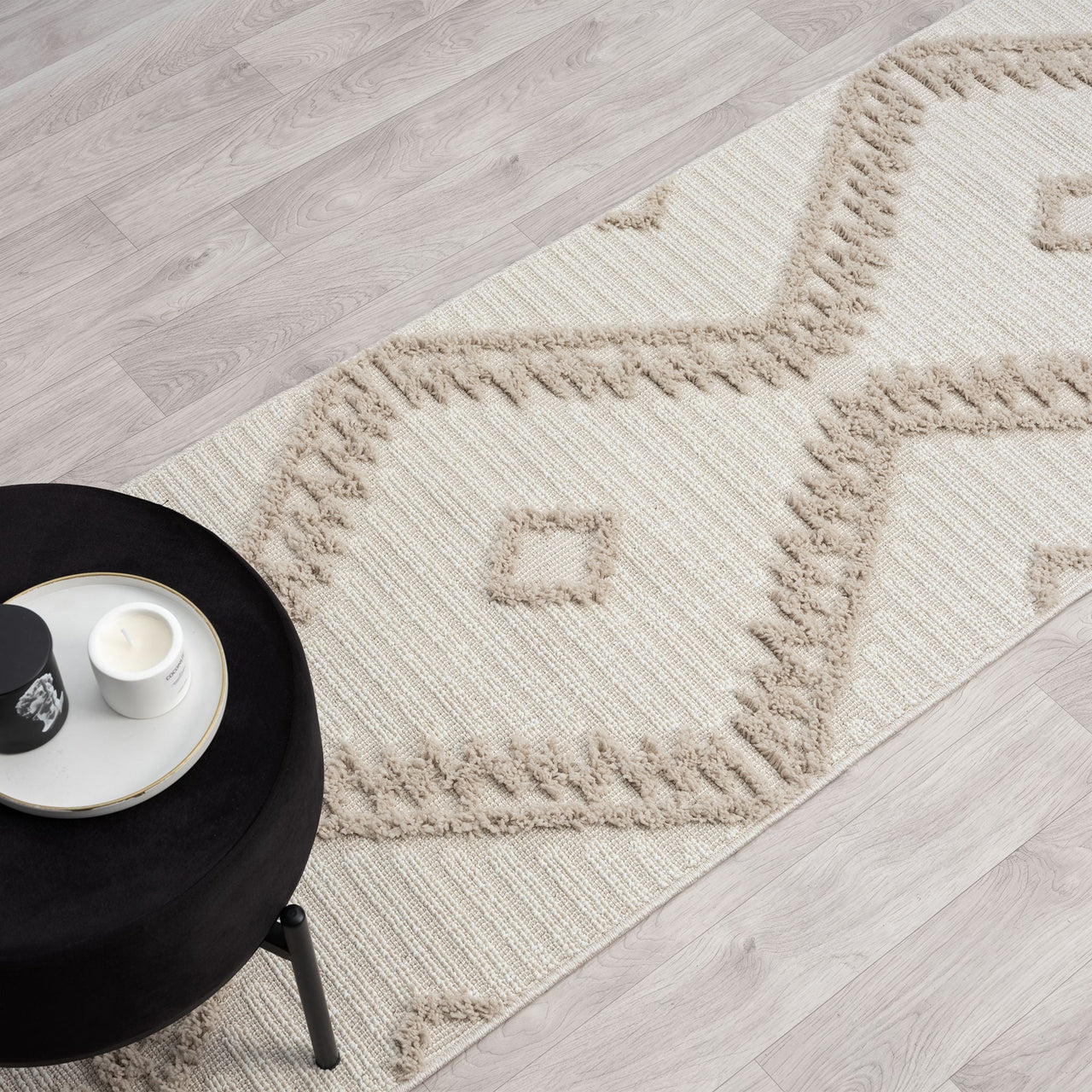 Taupe and beige runner rug with textured geometric diamond pattern and fringed edges on light wood floor.