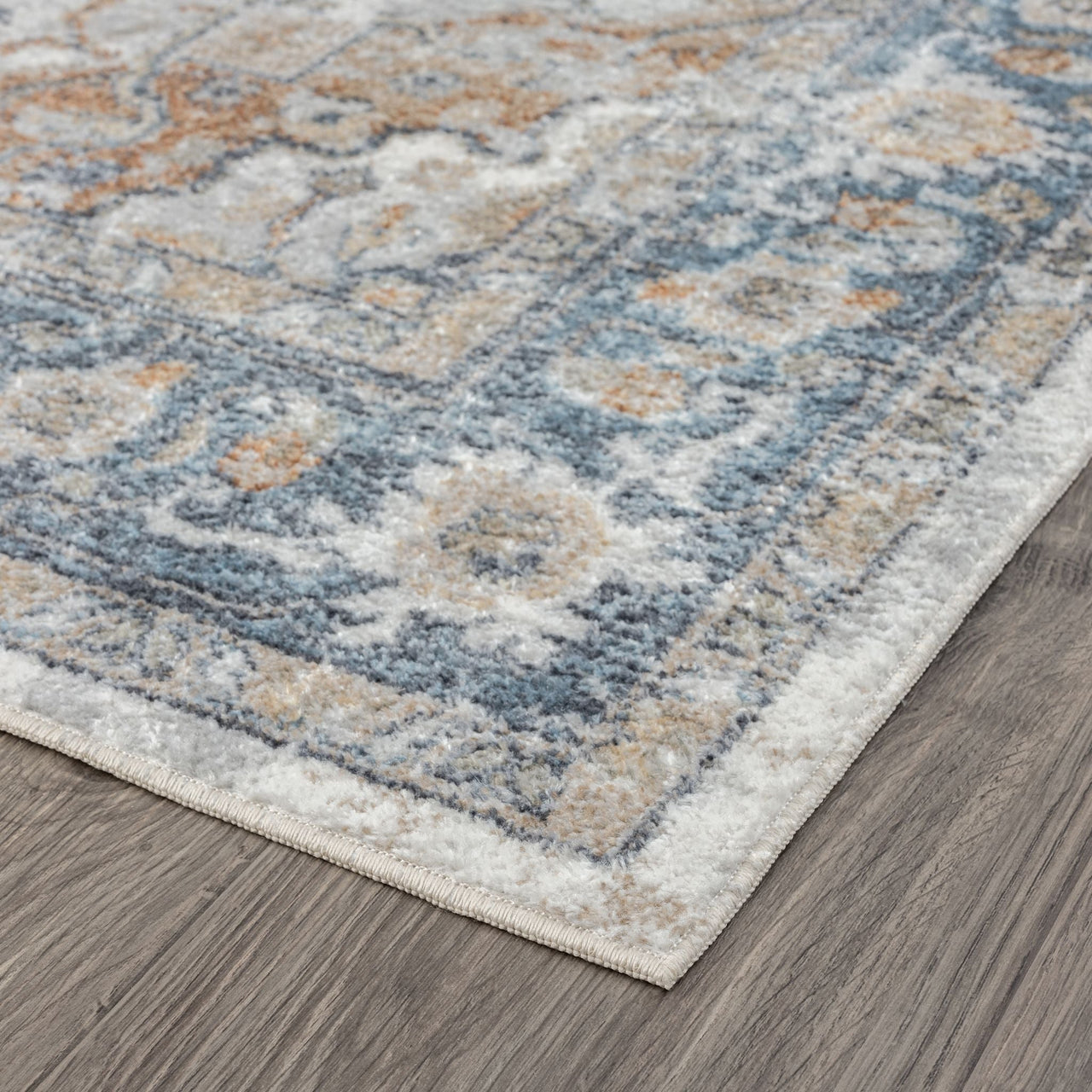 Modern transitional aqua runner rug with muted blue, beige, and cream geometric patterns on a hardwood floor.