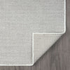 Grey flatweave runner rug with subtle geometric texture and clean white border on wood floor.