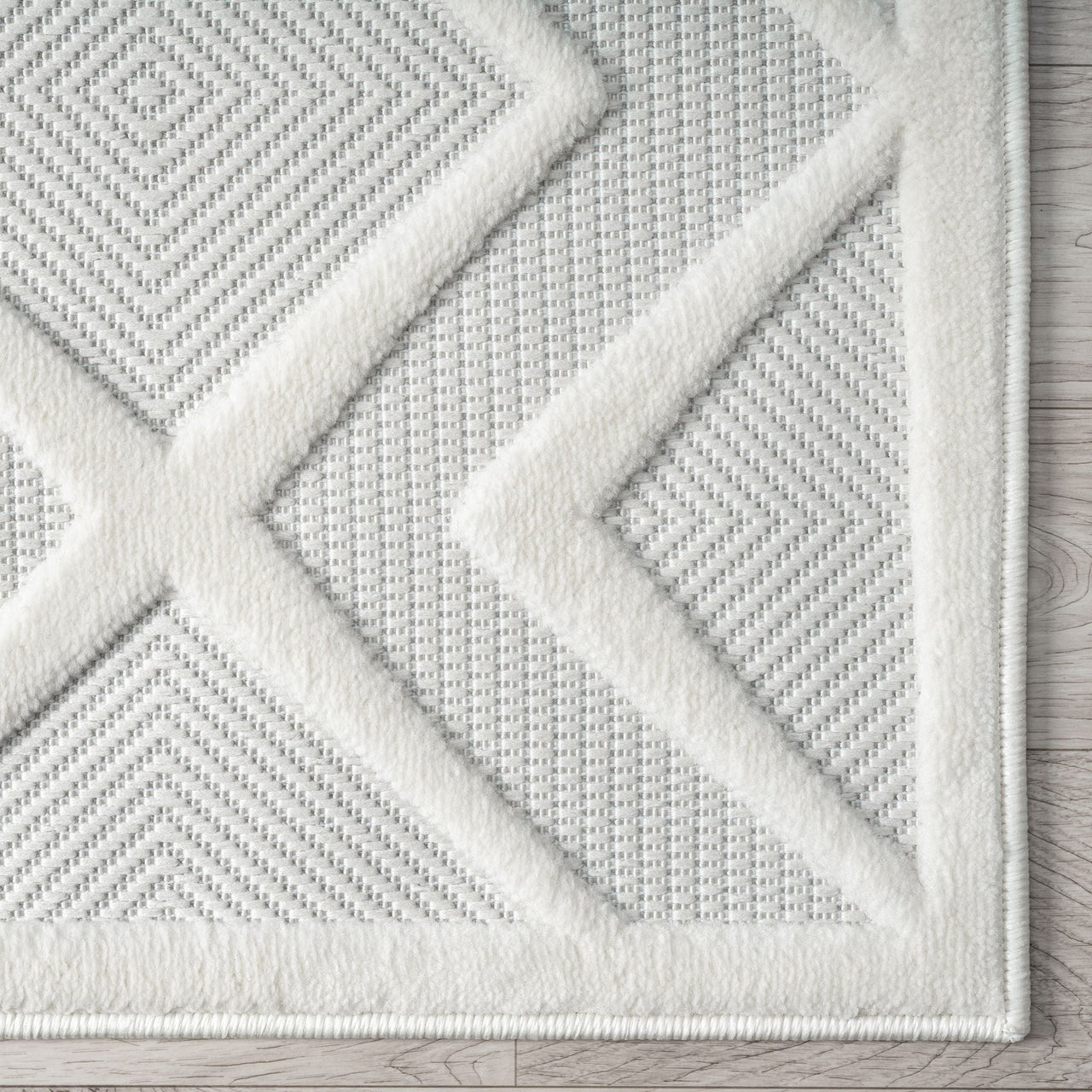 White modern rug with textured geometric pattern in raised polypropylene pile and woven base.