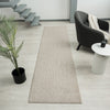 Taupe flatweave runner rug with subtle geometric texture on light wood floor.