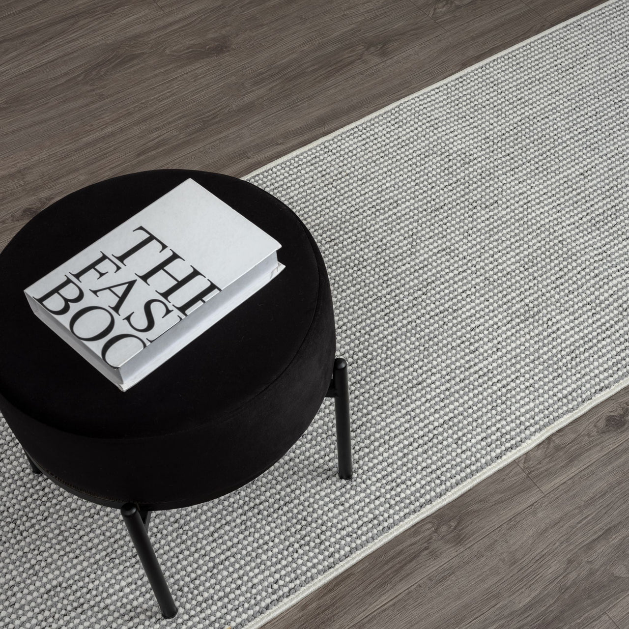 Grey flatweave runner rug with subtle geometric pattern on dark wood floor.