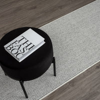 Grey flatweave runner rug with subtle geometric pattern on dark wood floor.