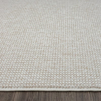 Beige flatweave rug with subtle geometric pattern and cream edging on hardwood floor.