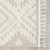 Beige and white geometric patterned rug with textured diamond design and fringed edges.