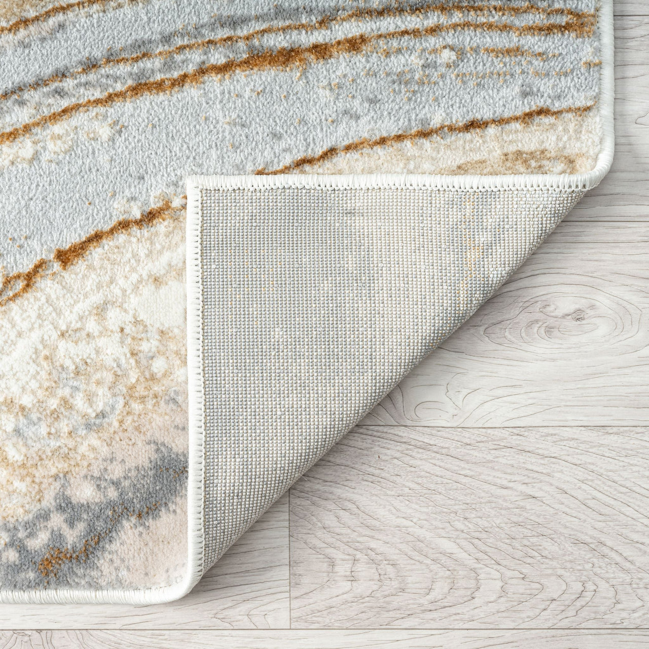 Close-up of a textured rug with a marble-like pattern on a wooden floor.