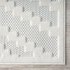 Cream rug with raised geometric squares and textured woven background in light neutral tones.