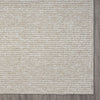 Taupe flatweave rug with subtle geometric pattern and textured edge trim.