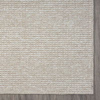 Taupe flatweave rug with subtle geometric pattern and textured edge trim.