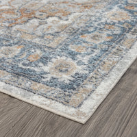 Blue and beige transitional rug with ornate floral and geometric patterns on a wooden floor.