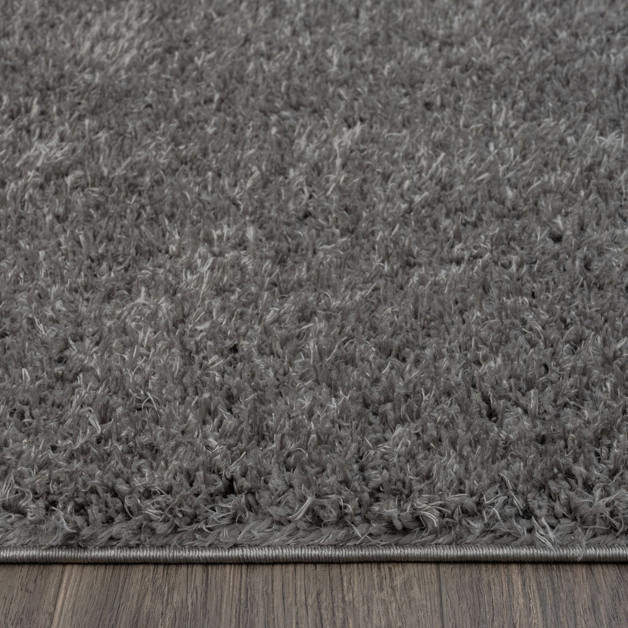 Grey shaggy runner rug with soft plush texture and subtle silver tones on hardwood floor.