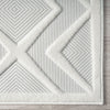 White runner rug with raised geometric diamond and triangle patterns on textured pile.