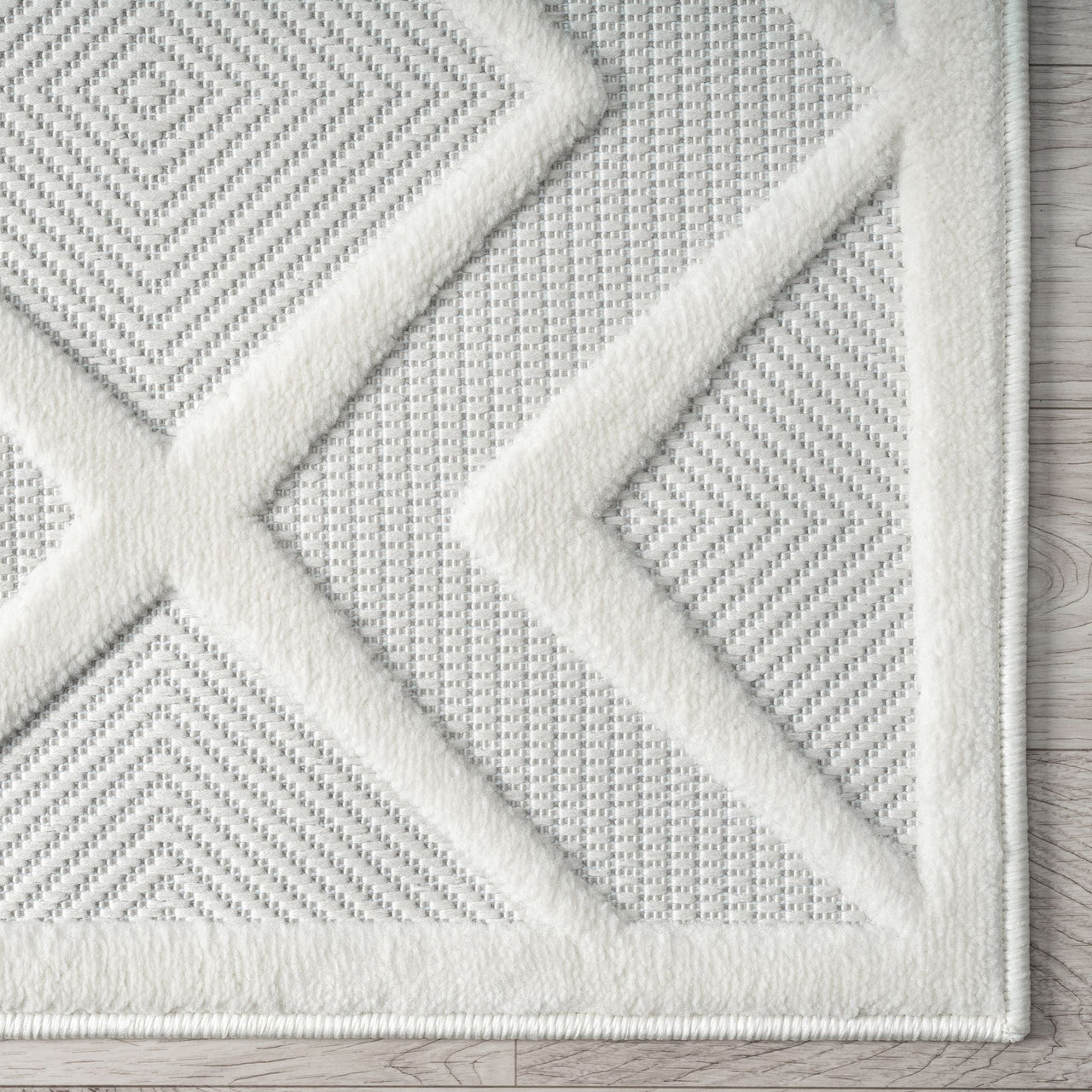 White runner rug with raised geometric diamond and triangle patterns on textured pile.