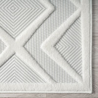 White runner rug with raised geometric diamond and triangle patterns on textured pile.