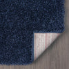 Navy blue modern shaggy runner rug corner showing dense polyester fibers and textured backing on wood floor.