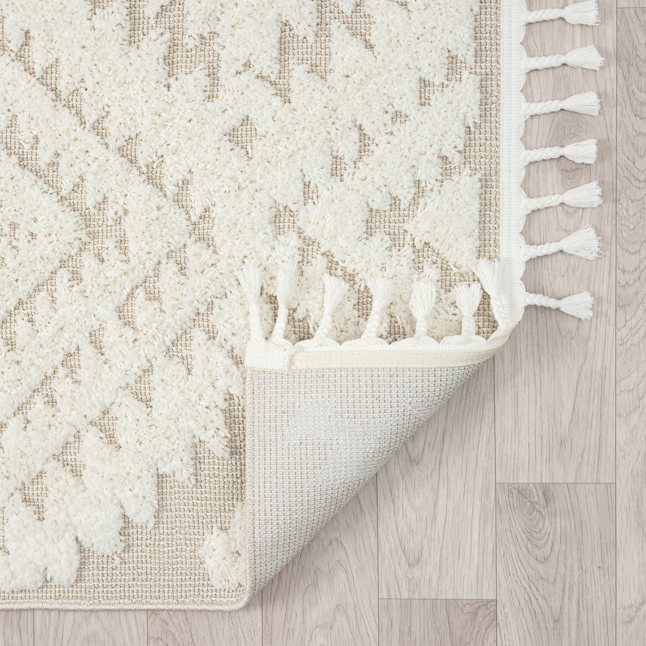 Beige and white modern geometric patterned runner rug with textured pile and fringed edges on light wood floor.