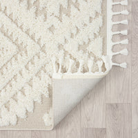 Beige and white modern geometric patterned runner rug with textured pile and fringed edges on light wood floor.