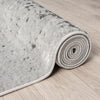 Rolled-up gray textured rug on a wooden floor