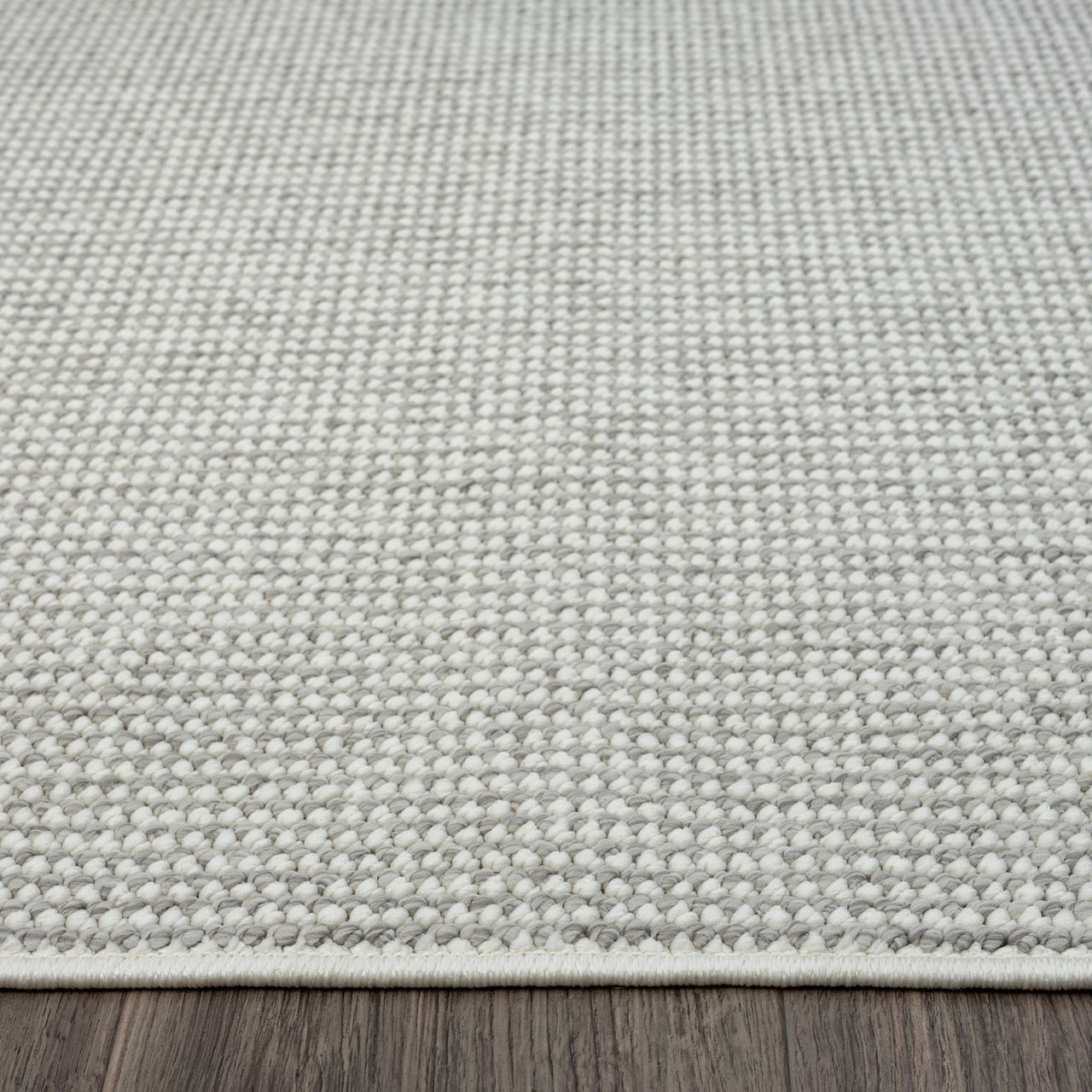Silver grey flatweave runner rug with subtle textured geometric pattern and clean edges on dark wood floor.