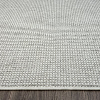 Silver grey flatweave runner rug with subtle textured geometric pattern and clean edges on dark wood floor.