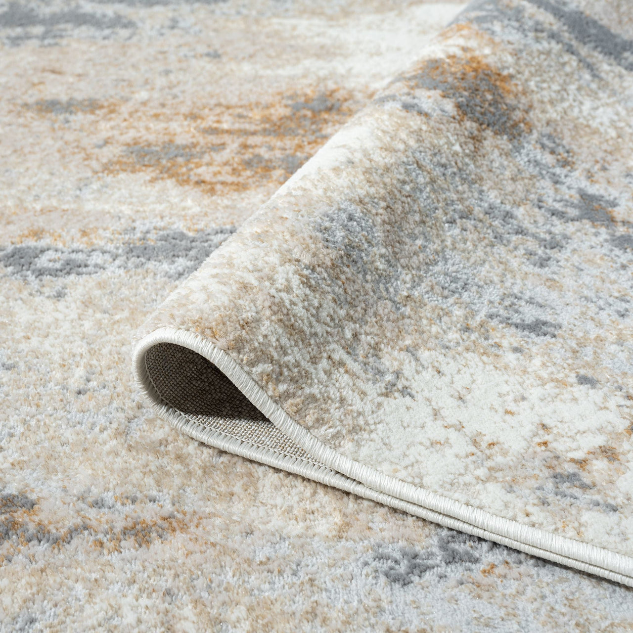 Close-up of a textured area rug with a neutral color palette.