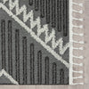 Grey and white modern geometric patterned runner rug with fringe edges and textured pile.