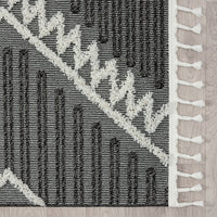 Grey and white modern geometric patterned runner rug with fringe edges and textured pile.