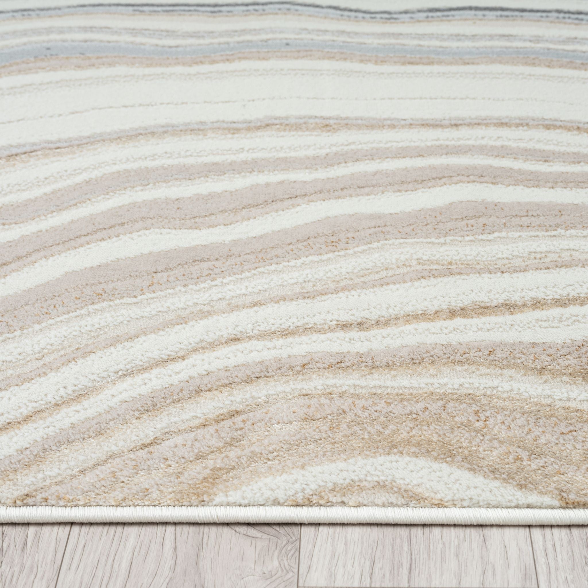Close-up of a textured rug with wavy pattern on a wooden floor.