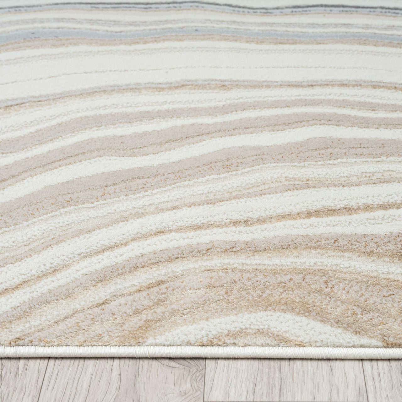 Close-up of a textured rug with wavy pattern on a wooden floor.