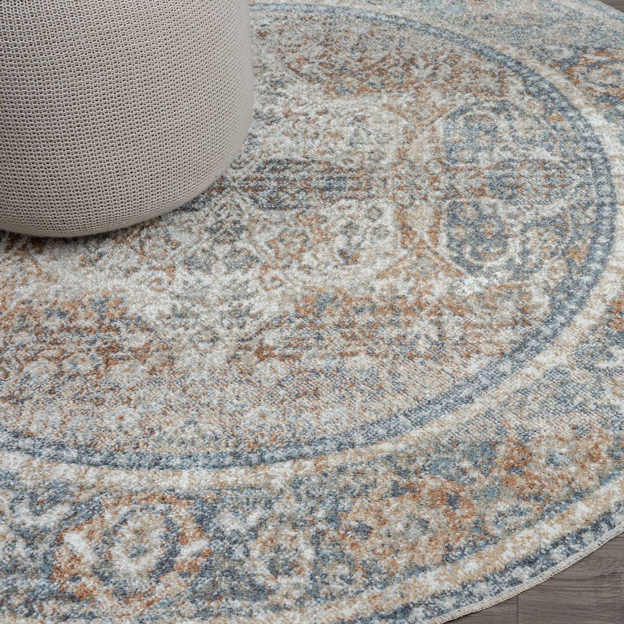 Round coral and blue patterned area rug with faded vintage design and textured weave.