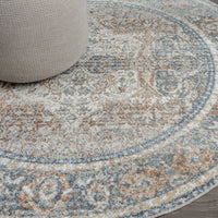Round coral and blue patterned area rug with faded vintage design and textured weave.
