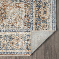 Coral and beige patterned runner rug with blue accents, power-loomed polyester blend, folded corner showing backing.