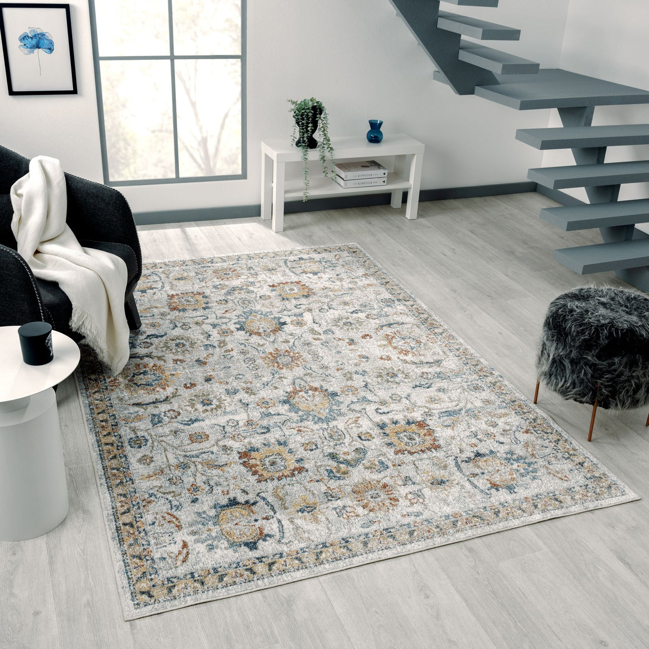 Multi-colored transitional rug with intricate floral and geometric patterns in soft blue, beige, and gray tones on light.